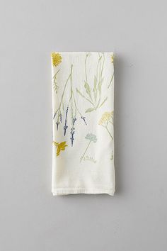 a white napkin with yellow and green flowers on it