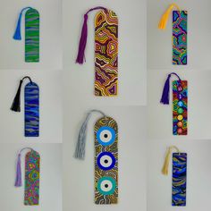 eight colorful bookmarks with different designs and tassels hanging from the top one has an evil eye on it