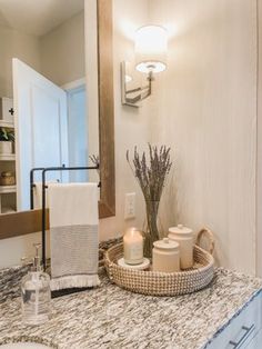 a bathroom counter with candles and towels on it