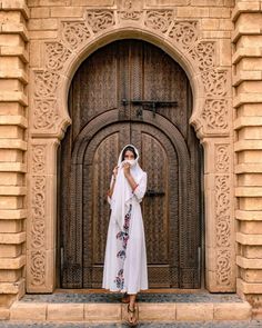 a woman standing in front of a wooden door