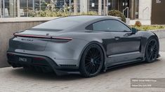 a grey sports car parked in front of a building