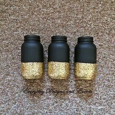 three black and gold mason jars sitting next to each other on a carpeted floor