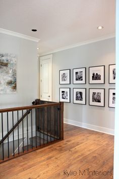 an entry way with pictures on the wall and wooden bannister railing in front of it