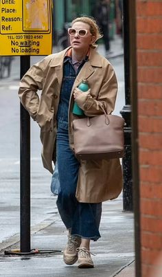 a woman is walking down the street with her purse