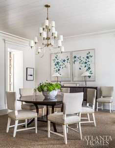 a dining room table with chairs and a chandelier hanging from it's ceiling