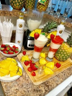 pineapples, strawberries, and other fruit on a kitchen counter