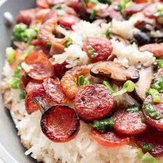 a plate with rice, sausages and vegetables on the top is ready to be eaten