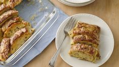 some food is sitting on a plate and next to a pan with bread in it