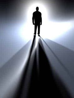 a man standing in the middle of a dark room with light coming from behind him