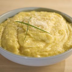 a white bowl filled with mashed potatoes on top of a wooden table