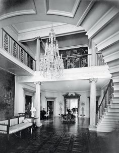 an elegant foyer with chandelier and marble flooring is pictured in this black and white photo