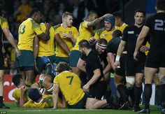 the rugby players are all huddled together on the field and one is holding his head in his hands