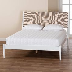 a white bed with an upholstered headboard and foot board in a room