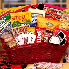 a red basket filled with lots of different types of snacks and candys sitting on top of a checkered table cloth