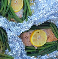 salmon and green beans wrapped in foil with lemon wedges on the side for garnish