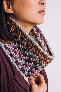 a woman is wearing a knitted scarf