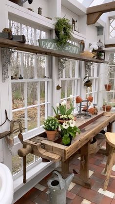 a room filled with lots of plants and potted plants on top of a wooden table