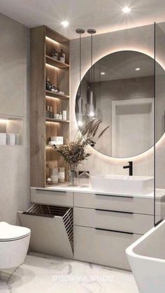 a bathroom with a large round mirror above the sink and white countertop, along with a toilet