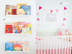 a baby's room with bookshelves, crib and stuffed animals on the wall