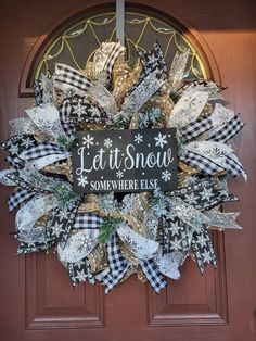 a black and white christmas wreath with the words let it snow somewhere else on it