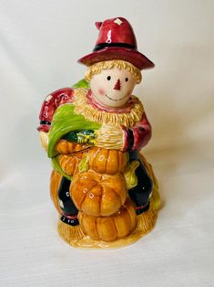 a ceramic figurine that is sitting on top of pumpkins