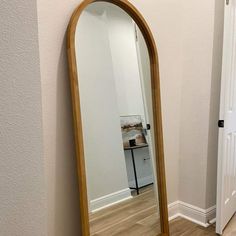 a large mirror sitting on top of a wooden floor