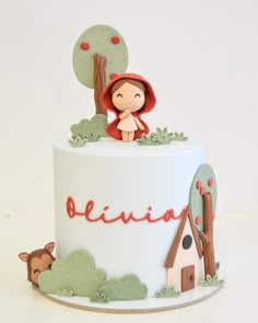 a white cake with a little red riding on the top and name belivia