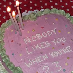 a heart shaped cake with candles on it that says nobody likes you when you're 23