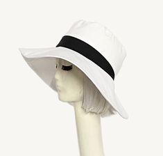 White cotton poly blend twill wide brim sun hat, the crown is 3 1/2 " in length with a black contrast band and a one piece 4" brim, lined in a rayon print with 1" soft black cotton band. One size fits most up to 23" Machine wash / dry Press if needed / packable Made in USA Wide Brim Sun Hat, Denim Hat, Soft Black, Wide Brimmed, White Cotton, Sun Hats, Black Cotton, Cotton Twill, One Piece