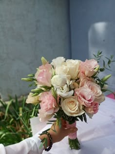 a person holding a bouquet of flowers in their hand