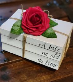 a red rose sitting on top of two white boxes with words written on the sides