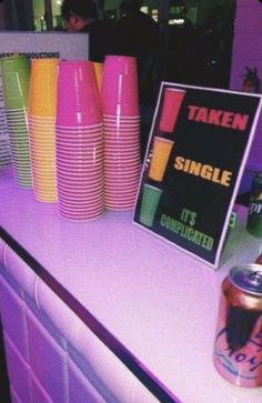 there is a table with neon colored cups on it and a sign that says taken single