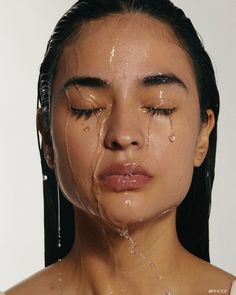 a woman with tears on her face and the water dripping from her eyes is covering her face