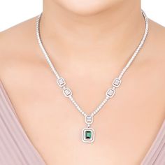 Elevate your elegance with the Evita Emerald Statement Necklace in Silver. This exquisite piece redefines luxury with its tennis necklace design. The centrepiece is a breath-taking pendant drop, featuring two distinct rectangular settings. The larger setting cradles a stunning lab-grown emerald, enveloped by two dazzling rows of zircons. This masterpiece gracefully connects to a smaller rectangular setting, where baguette-cut zircons are framed by a single row of glistening zircons.  Adding to i Elegant Gemstone Tennis Necklace For Anniversary, Elegant Emerald Necklace With Brilliant Cut, Elegant Cubic Zirconia Emerald Necklace, Emerald Statement Necklace, Silver Necklace Statement, August Birthstone Jewelry, July Birthstone Jewelry, Necklace Design, Tennis Necklace