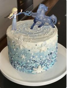 there is a frosted cake with a horse and snowflakes on the top