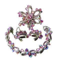 "The set has large a pink chaton, pink AB baguettes & small chaton rhinestones. The metal is a matte silver tone color finish very different from their other pieces. Bracelet, brooch and one earrings: signed HOLLYCRAFT COPR 1957 The clip earrings measure 1.20\" high by 0.95\" wide. The clips are tight. The brooch measure 2.35\" wide by 2.35\" high and the back pin is locking tight. The Bracelet measures 7.00\" long by 0.70\" wide. The clasp and the safety chain are both present and working fine. Excellent vintage condition. For more vintage jewelry click here: http://www.etsy.com/shop/vintagelanejewelry I describe my jewelry to the best of my ability, minor imperfections and wear consistent with age may be expected. Customer satisfaction is important to me. Any problems, I will work with y Pink Bling Jewelry For Evening, Evening Pink Bling Jewelry, Pink Crystal Jewelry For Evening, Pink Evening Jewelry With Bling, Pink Crystal Jewelry Brooch, Pink Crystal Brooch Jewelry, Evening Pink Costume Jewelry, Pink Costume Jewelry For Evening, Pink Brooch Jewelry For Evening