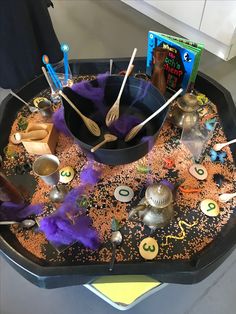 a tray with spoons, forks and other items on it that are in the shape of a witch's caulder