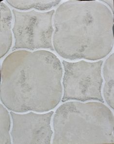 a close up of a tile floor with white and gray circles on the tiles,