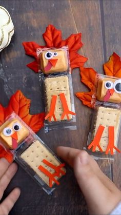 four turkey crackers in plastic bags on a wooden table with fall leaves around them