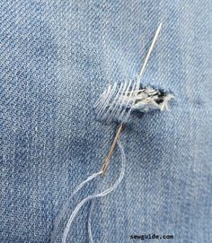 a piece of denim with some thread on it