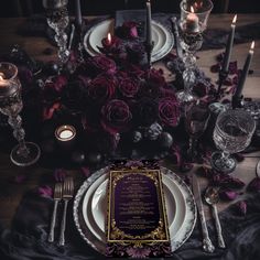 the table is set with silverware, candles and purple rose centerpieces for an elegant dinner