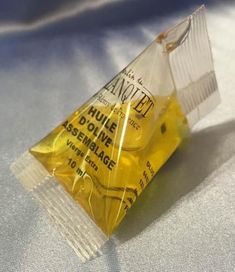 a small triangle shaped plastic bag filled with yellow liquid on top of a white sheet