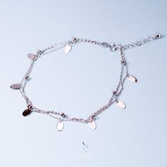 Indulge in the beauty of this sterling silver anklet, adorned with two layers of delicate ball charms and sophisticated eclipse tag dangle charms. Its platinum plating adds a touch of luxury to the elegant cable chain design. Whether as a treat for yourself or a thoughtful gift for a loved one, this double chain ankle bracelet will enhance any fine jewelry collection. Materials: 925 sterling silverFinish: platinum plateAnklet length: 8 in + 1.25 in adjustable chain. Jewelry Care: See more inform Elegant Silver Chain Bracelet With Dangling Charms, Dainty Silver Charm Bracelet With Dangling Charms, Silver Anklet, Sterling Silver Anklet, Silver Anklets, Chain Design, Double Chain, Ankle Bracelet, Chain Jewelry