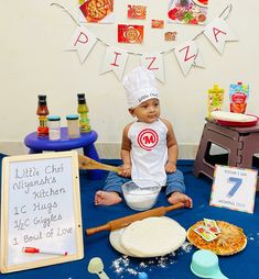 a baby is sitting on the floor in front of some pizzas and other items