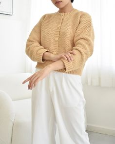 a woman standing in front of a window with her hands on her hips and looking off to the side