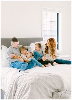 a group of people sitting on top of a bed