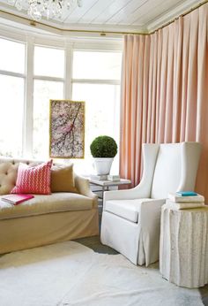 a living room filled with furniture and a chandelier hanging from the ceiling next to a window