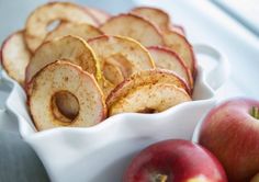 some apples are sitting in a white bowl