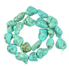 several turquoise stones are arranged together on a white surface, with one bead in the middle