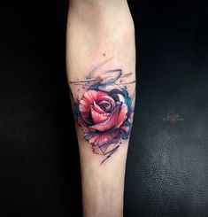 a rose tattoo on the leg with watercolor splashes and ink splatters